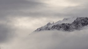 Snow-covered mountain peaks covered by clouds in Patagonia, Argentina. Pan left to right - Powered by Shutterstock - Get 15% off with code: PIKWIZARD15