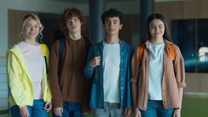 High school Caucasian group teenagers pupils students university college males females men women girls boys guys classmates friends posing standing together indoors smiling at camera education study