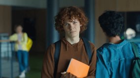 High school Caucasian sad upset lonely frustrated man male guy teenager teen boy schoolboy students walking going frown walk in university college corridor holding copybook couple teens push bullying - Powered by Shutterstock - Get 15% off with code: PIKWIZARD15