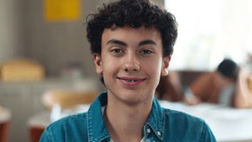 Portrait indoors happy smiling carefree Caucasian pupil teen boy teenager student guy teenage man male schoolboy looking at camera in class lesson classroom education study school university smile - Powered by Shutterstock - Get 15% off with code: PIKWIZARD15