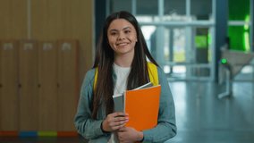 Happy smiling Caucasian student girl female schoolgirl woman pupil teenager teen walking going in school corridor walk in university hall education study hold copybooks learning go to class lesson - Powered by Shutterstock - Get 15% off with code: PIKWIZARD15