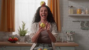 Hispanic Caucasian woman girl female having fun funny play with fruits at kitchen home enjoying joy smiling throw juggle juggling apples throwing laugh diet food delivery vegetarian nutrition health - Powered by Shutterstock - Get 15% off with code: PIKWIZARD15