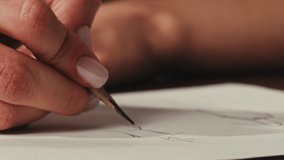 Young woman designer is drawing some clothes by pencil using ruler on white paper . The costume fashion designer making sketches for the work projects close-up. Drawing and sketching lessons - Powered by Shutterstock - Get 15% off with code: PIKWIZARD15