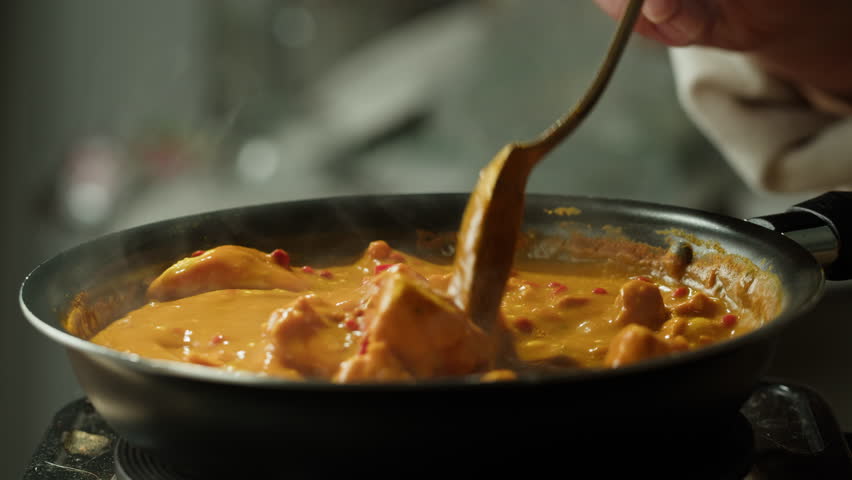 Yellow boiling sauce on pan close-up. Asian cuisine concept. Curry is a dish with a sauce seasoned with spices. Curries may contain fish, meat, poultry, or shellfish, either alone or in combination