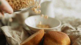 Breakfast Cereal rings Falling into bowl. Pouring honey cereal circles into a bowl. Cereal rings for morning breakfast. Bowl with corn flakes rings. - Powered by Shutterstock - Get 15% off with code: PIKWIZARD15