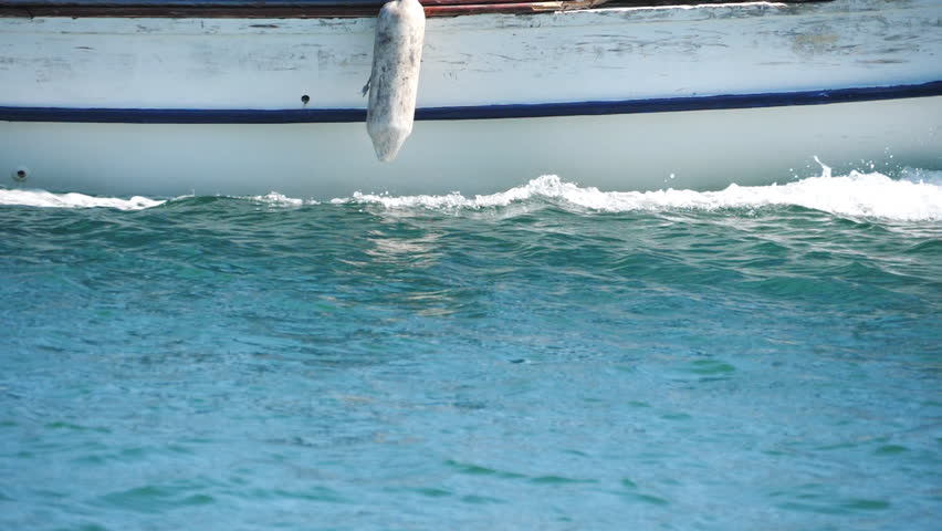 Side view of moving motorboat. Fast yacht floating along sea bay splashing calm water surface. Close up of sailboat traveling in ocean. Concept of summer vacation or holiday. Slow motion