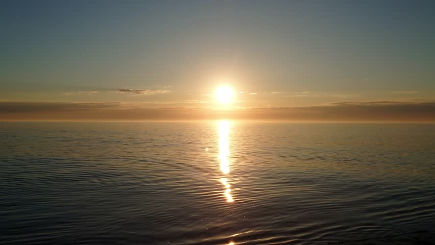 Breathtaking beauty of sunrise rising from sea with cloudy sky, for cinematic and scenic projects