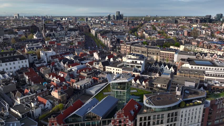 Historical Center of Amsterdam, Netherlands. Aerial Drone Shot of Traditional Dutch houses on narrow street and channel.