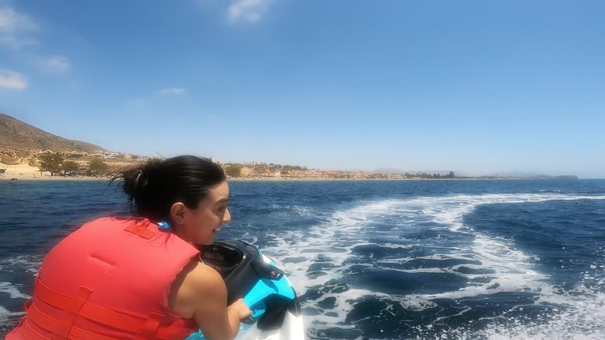 Couple drive a motorboat at full speed through the ocean POV
