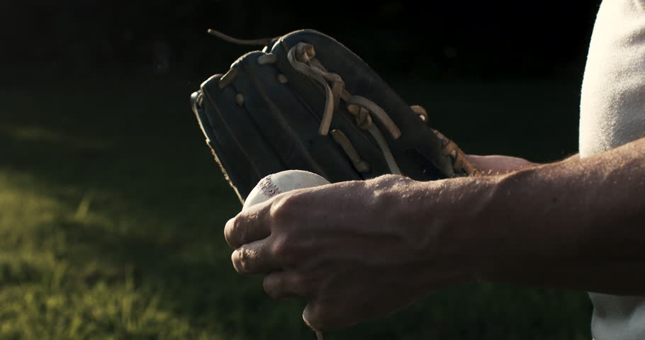 Super slow motion close up of baseball player practice with ball during workout before competition game match on baseball stadium on sunset at 1000 fps.