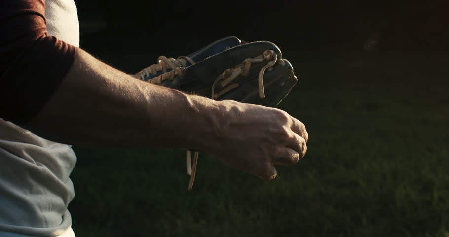 Super slow motion of baseball player practice with ball during workout before competition game match on baseball stadium on sunset at 1000 fps.
