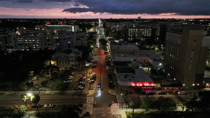 Drone flight over Main Street in Tampa at Night. Traffic on Road between buildings and homes. Aerial Birds Eye shot. Florida, USA.