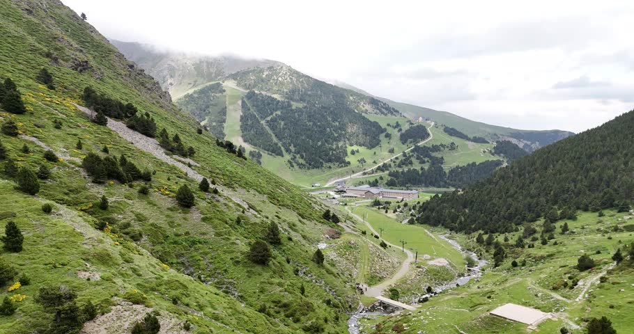 Aerial drone view of la Vall de Nuria, a sanctuary in the catalan Pyrenees surrounded by mountains and a lake.