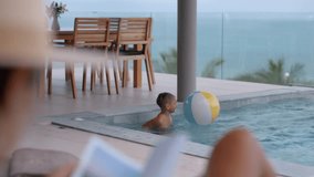 Child joyfully playing with a beach ball at a private pool with a beautiful view of the ocean - Powered by Shutterstock - Get 15% off with code: PIKWIZARD15