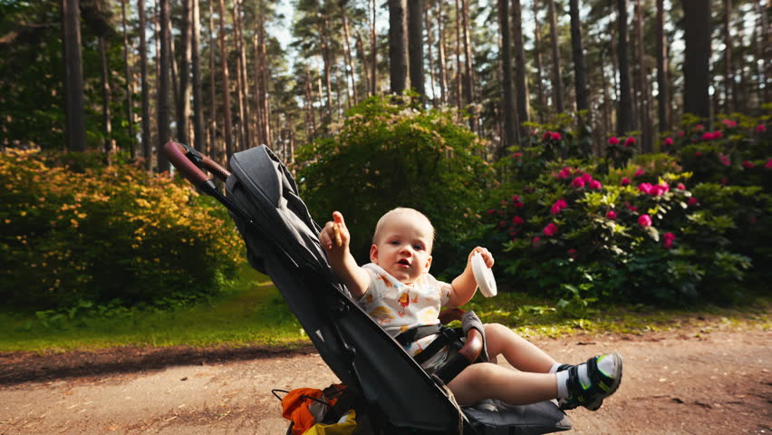 A baby is peacefully strolling through the park, enjoying nature on a sunny day, surrounded by beauty and tranquility