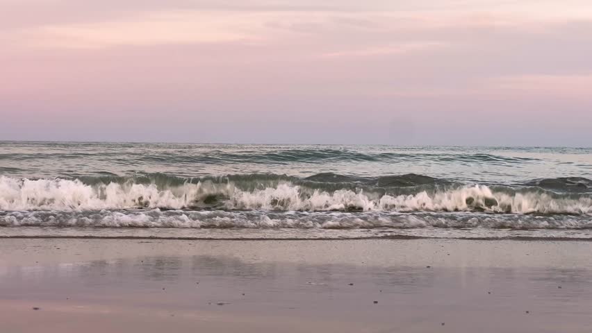 Waves Crashing on the beach at sunset with a cotton candy colored sky in the background in Myrtle Beach South Carolina.