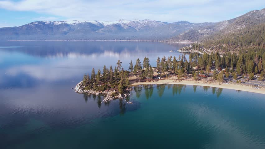 Drone Shot of Lake Tahoe USA on Sunny Winter Day, Sky Mirror Reflections on Calm Water. Sand Harbor Beach and Park