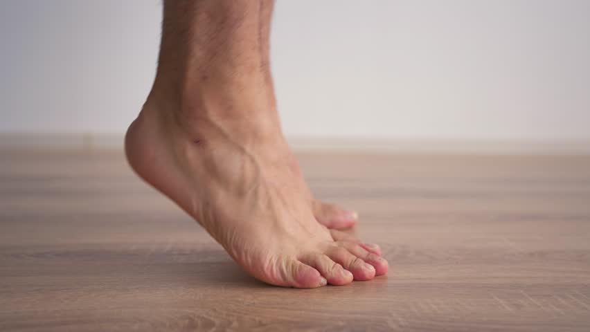 Close-up of Male Legs Doing Special Exercises to Treat Flat Feet. Concept of Therapeutic Physical Culture. Foot Health.