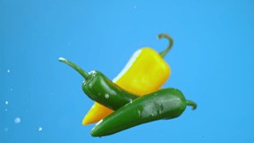 Green and yellow chili bell peppers jumping in air with water droplets, vegetables for cooking. High quality cinematic studio commercial super slow motion 1000fps fresh vegetables moving up and down. - Powered by Shutterstock - Get 15% off with code: PIKWIZARD15