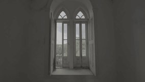 Gothic style arch open window in a empty room of an abandoned house with trees and a cloudy sky in the background (S-Log 3, ProRes 422HQ, 4K) - Powered by Shutterstock - Get 15% off with code: PIKWIZARD15