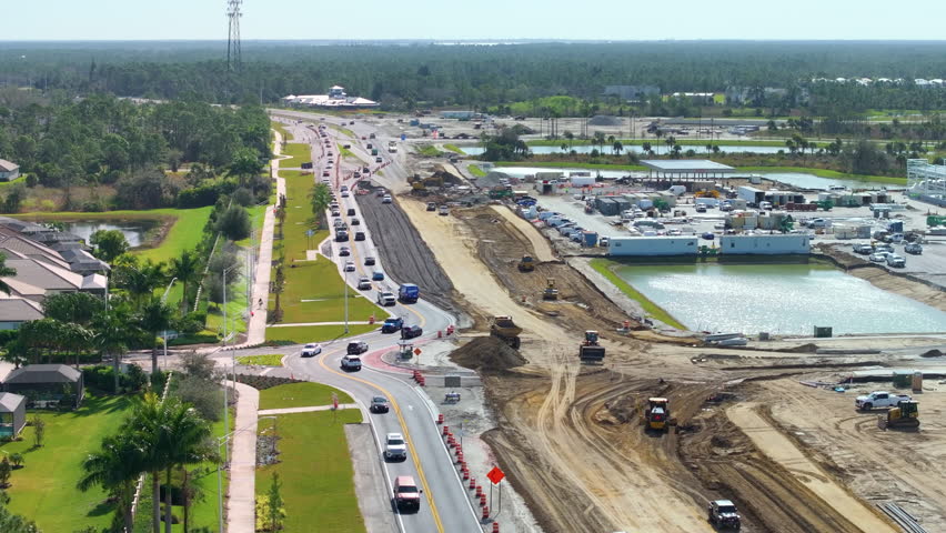 Roundabout intersection construction in North Port, Florida. Development of American road circle with moving traffic cars. Urban circular transportation crossroads.