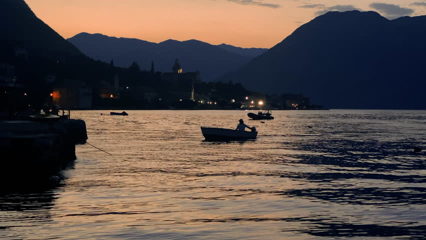 Boat sails to dock at sunset, Kotor Bay Montenegro