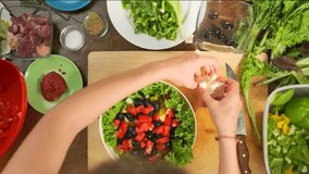 Top shot of preparing fresh summer Greek salad from feta cheese, tomatoes, cucumbers, bell peppers, olives, lettuce. Timelapse. - Powered by Shutterstock - Get 15% off with code: PIKWIZARD15