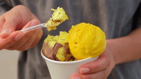 A woman's hand picks up ice cream balls with a spoon. The girl is eating ice cream - Powered by Shutterstock - Get 15% off with code: PIKWIZARD15