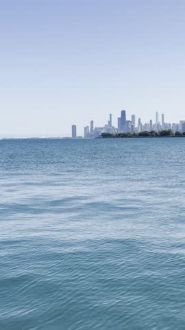 A Tranquil Morning at the Lakeshore in Chicago, Illinois with Skyline in the background with rocks getting splashed.