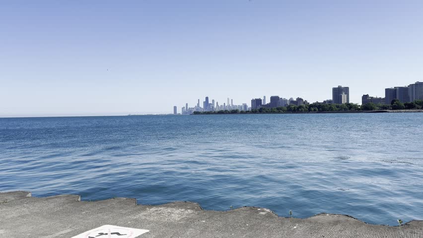 A Tranquil Morning at the Lakeshore in Chicago, Illinois with Skyline in the background with rocks getting splashed.