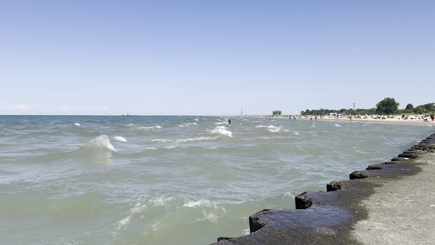A Tranquil Morning at the Lakeshore in Chicago, Illinois with Skyline in the background with rocks getting splashed.