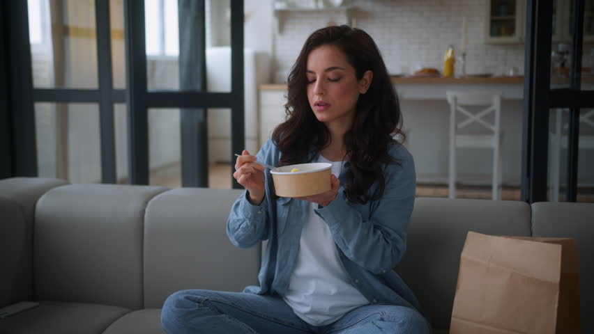 Happy Caucasian hunger girl female enjoy take away order meal lady woman at home sofa couch eating delivery food dish eat cafe restaurant courier service enjoying tasty dancing nutrition diet vegan