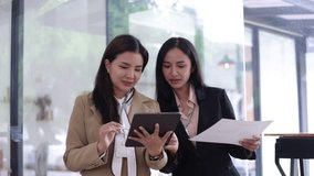 Two happy Asian female working together using digital tablet planning project, Financial data and Business people talking together in office. - Powered by Shutterstock - Get 15% off with code: PIKWIZARD15