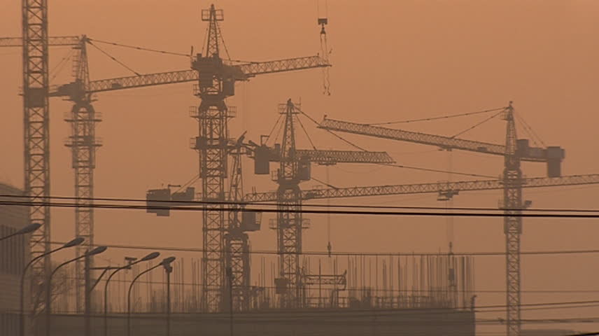Construction cranes and sunset