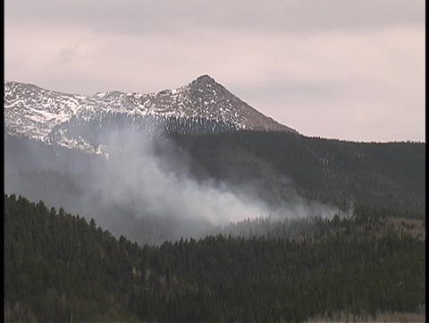 A forest fire, marked by the plumes of smoke, burns on the northwest slope of Pikes Peak on a very windy day