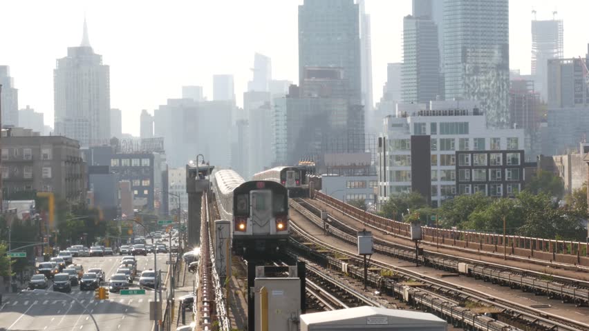 New York subway station. Metro train, metropolitan platform, United States public transportation. Elevated outdoor railway, 7 line, Queens. NYC passenger railroad traffic. Manhattan, Empire State view