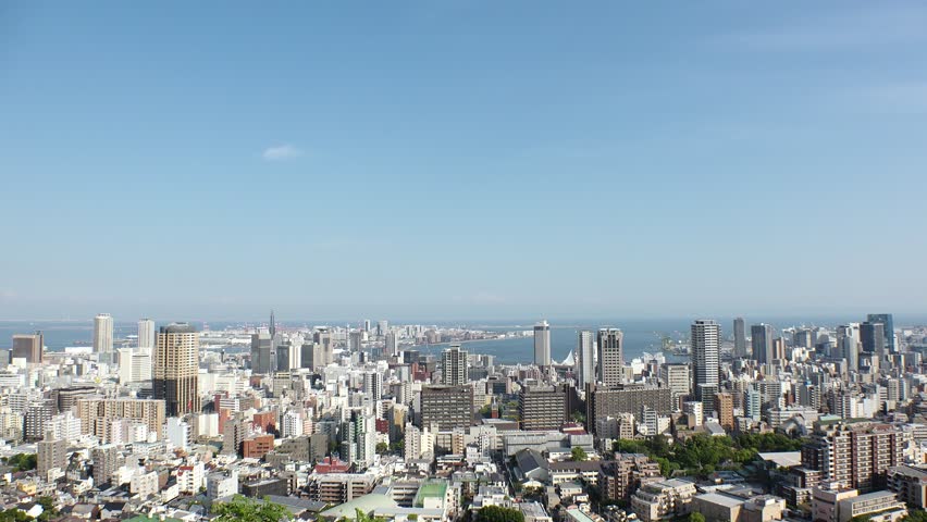KOBE, HYOGO, JAPAN - JUNE 2024 : Aerial high angle view of Kobe city and Kobe port in daytime. View of buildings and street around Kobe port tower and Sannomiya station.