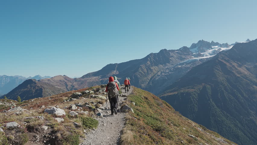 Group of hiker hiking on top of mountain with Mont Blanc massif among the French Alps on sunny day at Chamonix, France