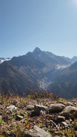 Male hiker relaxing and eating apple on edge of mountain at Mont Blanc massif in French Alps at Chamonix, France