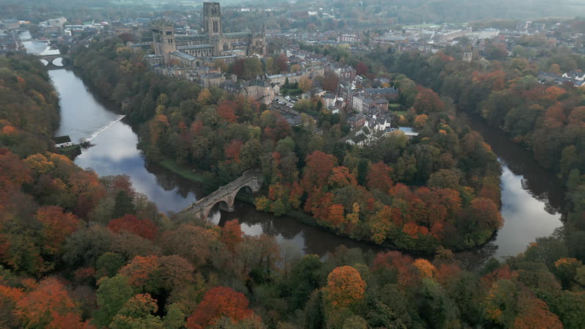 Drone circles the old city of Durham, England with the Cathedral and Prebends Bridge. Shot mid autumn