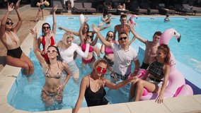 Group of friends and singers at summer pool party enjoy warm weather, sing and swim dressed and in open bikinis on holidays. Male and female going crazy, having fun, laughing loud and dancing. - Powered by Shutterstock - Get 15% off with code: PIKWIZARD15