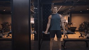Young Caucasian American Male Working Out in Gym Doing a Bicep Curl with Heavy Dumbbell Weights. Keeping Fit and Healthy Arms with Strength Training, Focused and Motivated - Powered by Shutterstock - Get 15% off with code: PIKWIZARD15