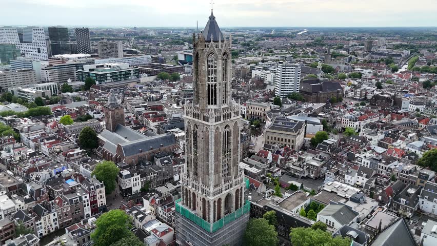 Capturing a breathtaking aerial drone shot of the historic Dom Tower in Utrecht, Netherlands, with the vibrant cityscape unfolding around it.