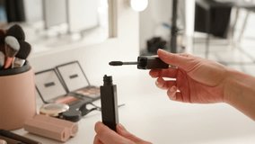 Unrecognizable Caucasian girl female model blog makeup artist hands holding twist opening mascara tube showing decorative cosmetics taking out black brush for eyelashes visage home table woman beauty - Powered by Shutterstock - Get 15% off with code: PIKWIZARD15