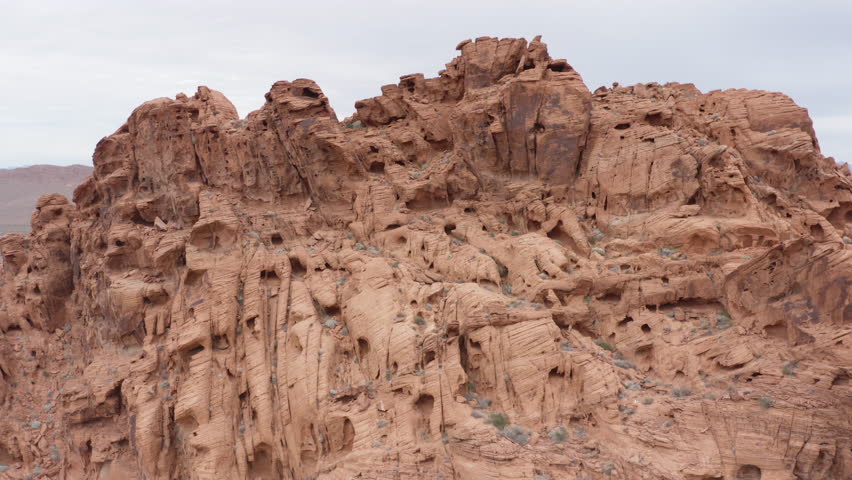 Cinematic pullback shot of red sandstone formation resembling landscape on Mars, aerial drone shot