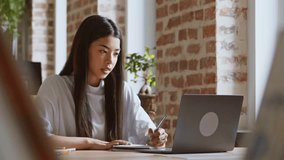 E-learning process. Spy view on asian student girl making notes, looking at computer screen, following professor - Powered by Shutterstock - Get 15% off with code: PIKWIZARD15