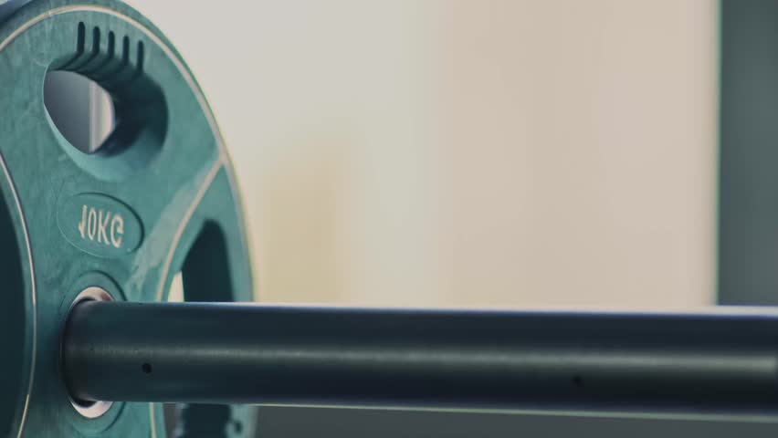 Strong man adding weights on barbell, preparing gym equipment for his training, close up. Weightlifting concept - Powered by Shutterstock - Get 15% off with code: PIKWIZARD15