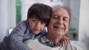 Grandfather and young boy sharing a joyful hug, showcasing family bonds and intergenerational love in a cozy home setting with natural light - Powered by Shutterstock - Get 15% off with code: PIKWIZARD15