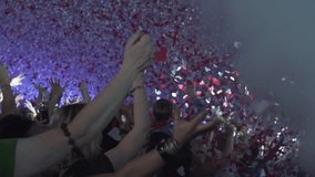 A vibrant and joyous concert crowd with hands raised celebrating under a shower of colorful confetti and heart-shaped pieces creating an electric and festive atmosphere with bright lights - Powered by Shutterstock - Get 15% off with code: PIKWIZARD15