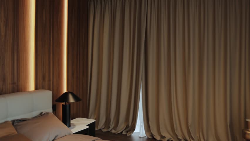 Cozy bedroom in beige tones with large bed, nightstand with lamp on it, the curtains open automatically, large windows, and coffee tray with two cups of coffee.